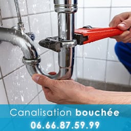 mains qui tiennent une pince pour déboucher une canalisation